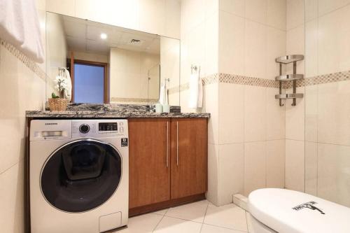a washing machine in a bathroom with a mirror at Frank Porter – Saba 2 in Dubai