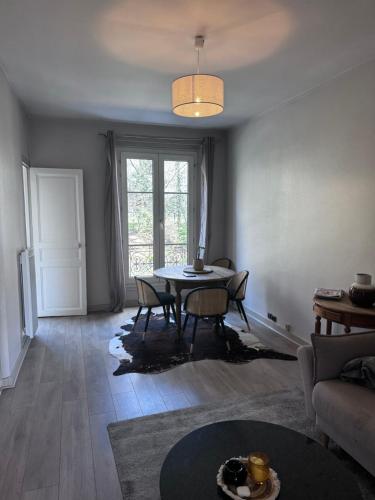 een woonkamer met een tafel en stoelen bij Spacieux appartement à 50m du Sacre Coeur - Magnifique Vue in Parijs
