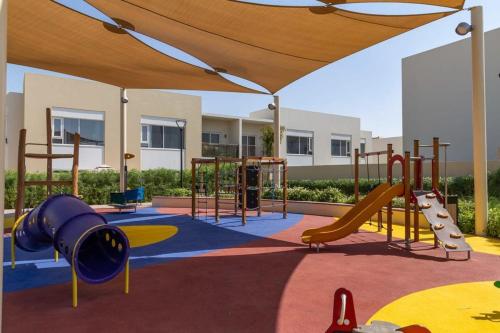 a playground with a slide and swings at Frank Porter - Urbana II in Dubai