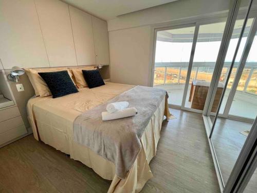 a bedroom with a bed with a view of the ocean at UNU Armação in Salvador