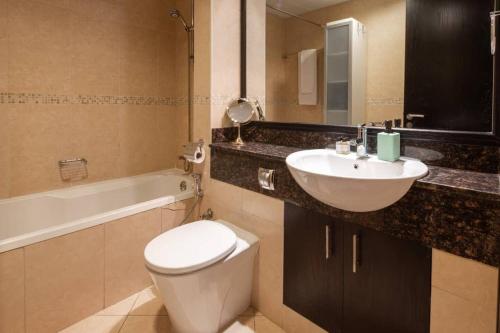 a bathroom with a white toilet and a sink at Frank Porter - Goldcrest Views in Dubai