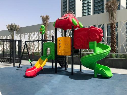 a playground with colorful play equipment in front of a building at Frank Porter - Bella Rose in Dubai