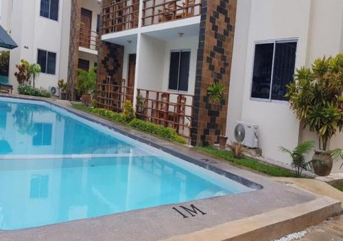 a swimming pool in front of a building at Tranquil Pendo villas in Diani Beach