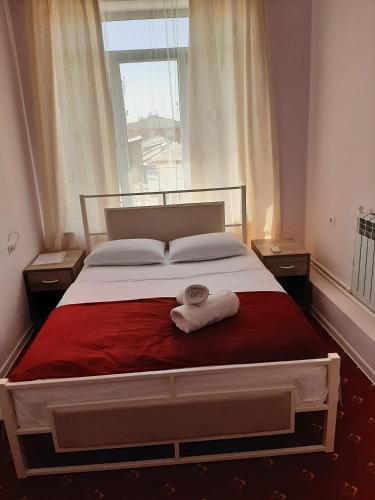 a bedroom with a large bed with two towels on it at Hotel Erebuni Plaza in Yerevan