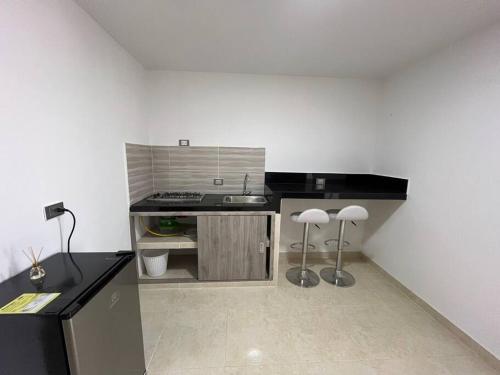 a kitchen with a sink and two stools in it at Apto 301 cerca a C.C. unicentro in Cúcuta