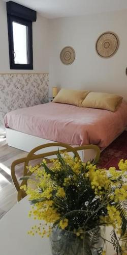 une chambre avec un lit et une table avec un vase de fleurs dans l'établissement Studio en rez de jardin, à Collobrières