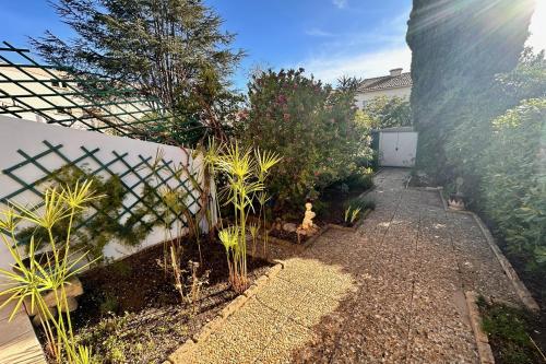 un jardin avec une clôture et quelques plantes dans l'établissement LES PINEDES - Un jardin fleuri à côté de la plage, au Grau-du-Roi