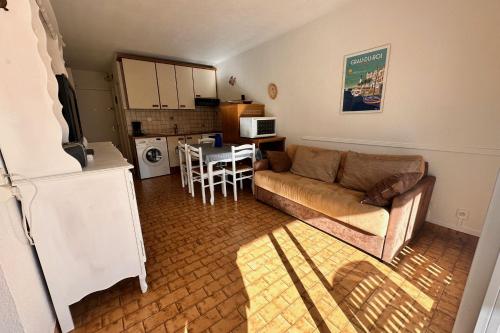 un salon avec un canapé et une table dans l'établissement LES PINEDES - Un jardin fleuri à côté de la plage, au Grau-du-Roi