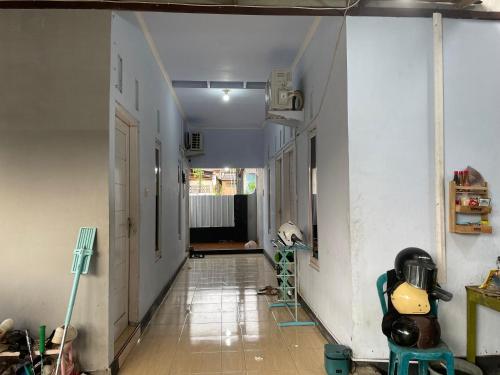 un couloir vide avec un mur blanc et une chambre dans l'établissement Wisma Sadewa, à Pangenjurutengah