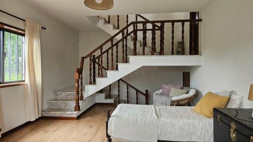 a living room with a bed and a staircase at Swara Slow Living Home in Aveiro