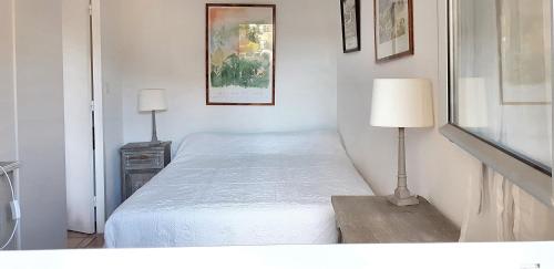 カブールにあるAppartement d'une chambre a Cabourg a 100 m de la plage avec piscine partagee jardin amenage et wifiの小さなベッドルーム(ベッド1台、ランプ付)