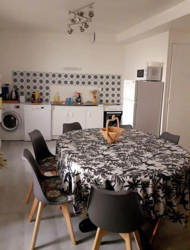 Il comprend une cuisine équipée d'une table et de chaises. dans l'établissement Logis cosy, à Pithiviers