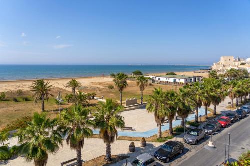 um parque de estacionamento com palmeiras e uma praia em Sicilia Bedda casavacanze em Pozzallo