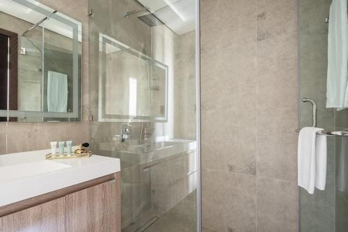 La salle de bains est pourvue d'une douche, d'un lavabo et d'un miroir. dans l'établissement Frank Porter - Majestique Residence 2, à Dubaï