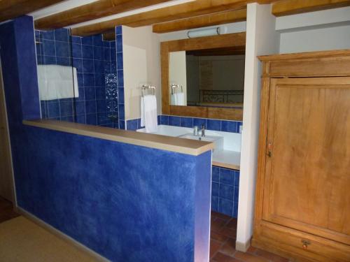 a blue tiled bathroom with a sink and a mirror at Hotel El Cerco in Puente la Reina