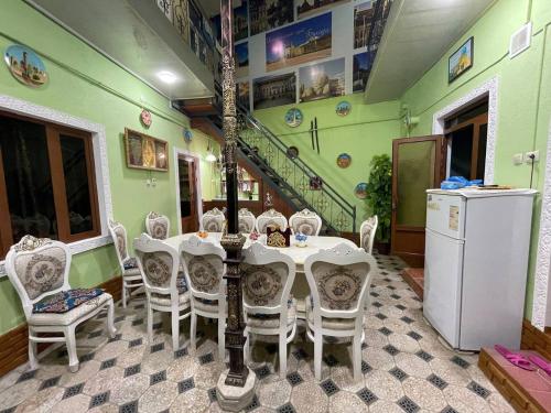 a dining room with a table and chairs and a staircase at Hotel Uncle Kolya Boutique in Bukhara
