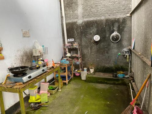 une cuisine sale avec de l'eau dans une pièce sale dans l'établissement Wisma Sadewa, à Pangenjurutengah
