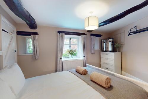 a bedroom with a large white bed with two towels at The Barn Timberscombe in Timberscombe