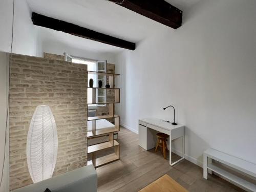 Cette chambre blanche dispose d'une table et d'un bureau. dans l'établissement Le Multipliant, à Montpellier
