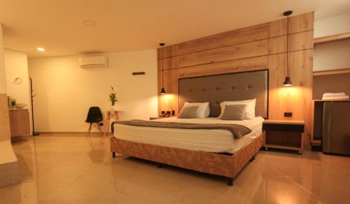 a bedroom with a large bed with a wooden headboard at Hotel California Center in Medellín