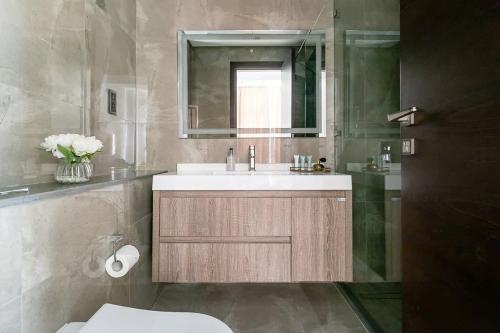 W łazience znajduje się umywalka, lustro i toaleta. w obiekcie Frank Porter - Majestique Residence 2 w Dubaju