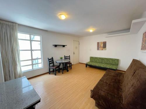 un soggiorno con un divano e un tavolo di Suites Havre a Città del Messico