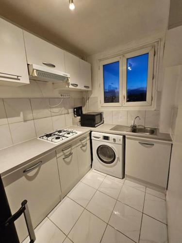 Il comprend une cuisine équipée d'une cuisinière, d'un évier et d'un lave-linge. dans l'établissement Bel appartement à Choisy-le-roi, à Choisy-le-Roi