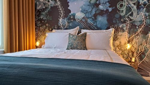 - une chambre avec un grand lit et du papier peint floral dans l'établissement Boutique Appartement Sparrenduin met airco, au Coq