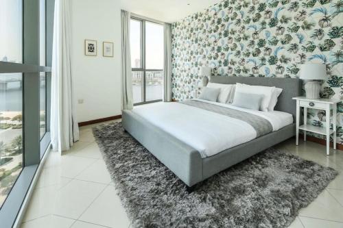1 dormitorio con 1 cama y papel pintado con motivos florales en Frank Porter - Marsa Plaza en Dubái
