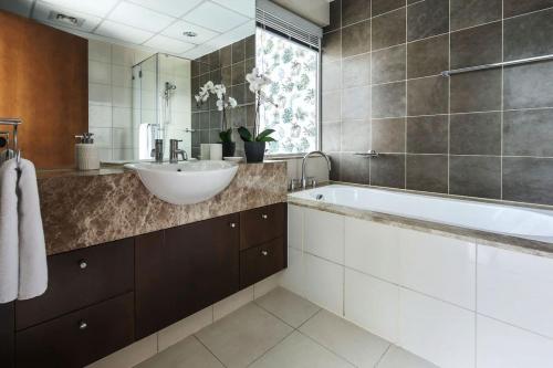 a bathroom with a sink and a bath tub at Frank Porter - Marsa Plaza in Dubai