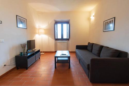 a living room with a couch and a tv at Borgo Gatteraia in Volterra