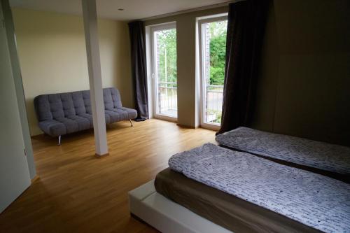 Zimmer mit 2 Betten, einem Sofa und einem Fenster in der Unterkunft Ferienhaus Celeste in Warnemünde