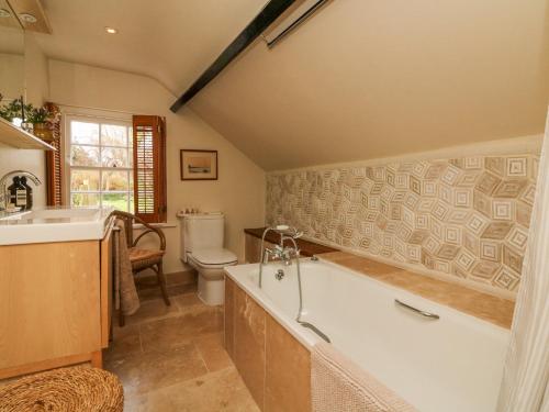 een badkamer met een bad, een toilet en een wastafel bij Blackbird Cottage in Bideford
