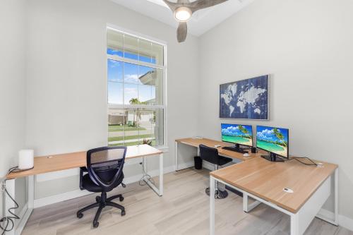 an office with two desks and a computer monitor at 2024 Monsterrat model waterfront home with lap pool in Marco Island