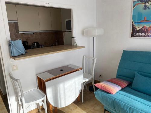 un salon avec un canapé bleu et une table dans l'établissement Soleil et Mer, à Saint-Raphaël