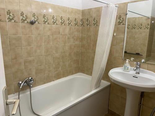 une salle de bain avec une baignoire et un lavabo dans l'établissement Soleil et Mer, à Saint-Raphaël