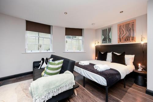 1 dormitorio con 2 camas y sofá en Charming Brighton Studio Flat, en Brighton & Hove