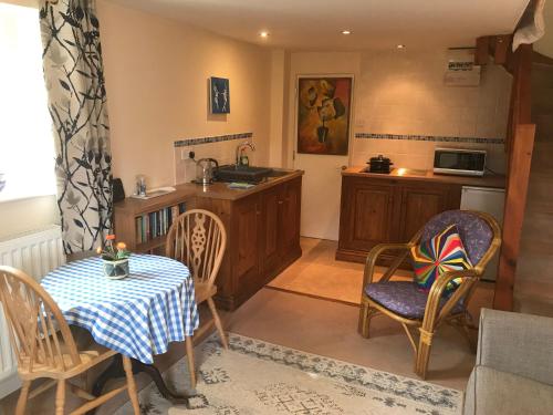 een keuken en eetkamer met een tafel en stoelen bij The Barn @ Bishops Lydeard in Taunton