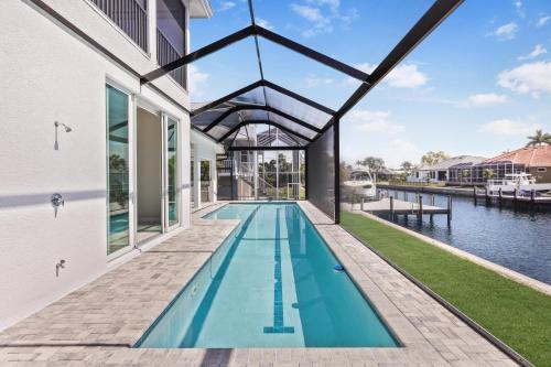 an indoor swimming pool in a house next to the water at 2024 Monsterrat model waterfront home with lap pool in Marco Island