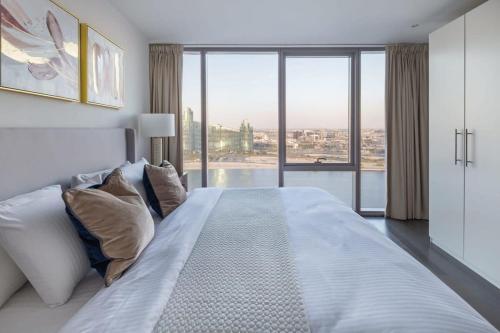 a bedroom with a large bed with a large window at Frank Porter - D1 Jaddaf in Dubai
