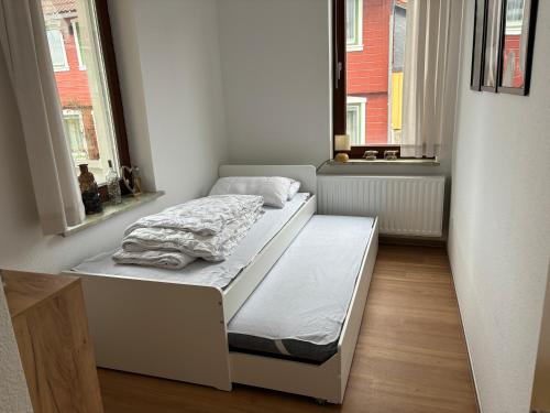 a bed in a room with two windows at Ferienwohnung Daisy in Sankt Andreasberg