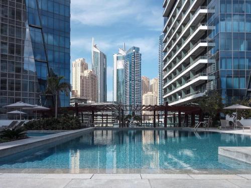 a large swimming pool in a city with tall buildings at Frank Porter - Silverene in Dubai
