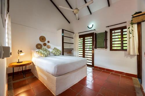 a bedroom with a white bed and a table at La Mello Country House in Palomino