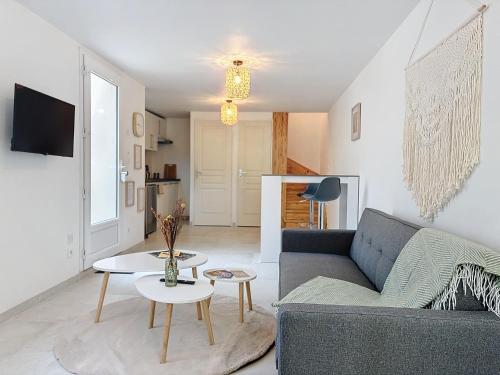 a living room with a couch and a table at Le Jardin des Plantes Rouen Studios et F2 au calmes, Terrasse, stationnement gratuit in Rouen