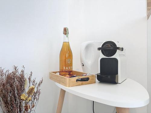 a bottle of wine sitting on top of a table at Le Jardin des Plantes Rouen Studios et F2 au calmes, Terrasse, stationnement gratuit in Rouen