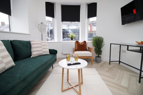 sala de estar con sofá verde y mesa en Centrally Located 2 Bedroom, en Cardiff