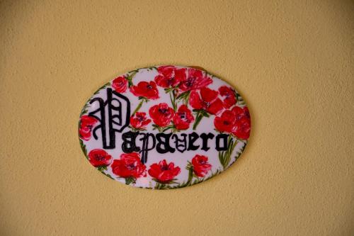 a plate with red flowers on a wall at Villa Belvedere in Pieve Fosciana