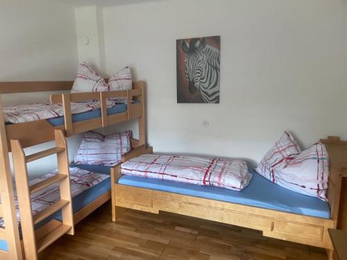 a room with three bunk beds and a picture of a zebra at Ute Urbaner in Irschen
