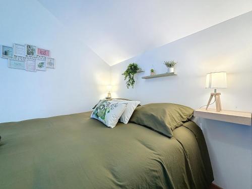 a bedroom with a bed with a lamp on it at Le Jardin des Plantes Rouen Studios et F2 au calmes, Terrasse, stationnement gratuit in Rouen
