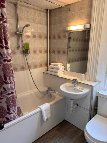 a bathroom with a tub and a sink and a shower at Hotel 24 in London